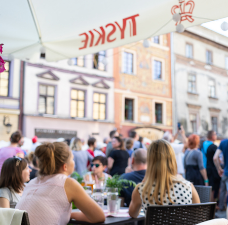 Lublin, Poland - Jul 27, 2018: Crowds of tourists and holidaymakers on the streets of the old city of Lublin. Blurred out of focus image of people in a street cafe. Lublin is the ninth largest city in Polandのeditorial素材
