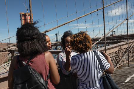 NEW YORK, USA - Sep 22, 2017: NYC street scene. New Yorkers and tourists walking on the Brooklyn Bridge. Manhattan skyline in backgroundのeditorial素材
