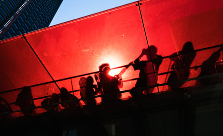 Manhattan street scene. Silhouettes of people on the red staircase in Times Square in New York City