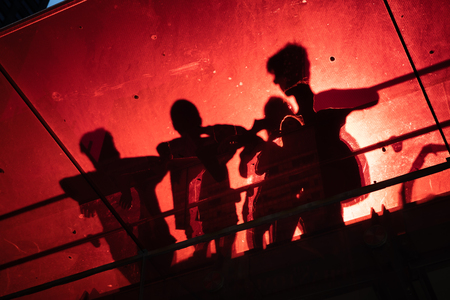 Manhattan street scene. Silhouettes of people on the red staircase in Times Square in New York City