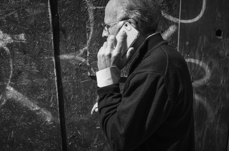 New York, USA - Sep 24, 2018: Black and white image of Manhattan street scene. The Americans on the streets of New York City. Old man with a mobile phoneのeditorial素材