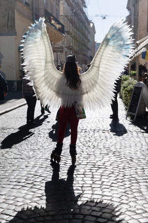Lviv, Ukraine - Oct 14, 2018: Young girl with angel wings and rollers on the streets of Lvivのeditorial素材