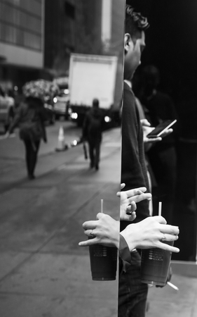 New York, USA - May 03, 2016: Coffee break in the streets of New York City. Hand of a woman with a...