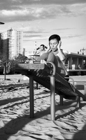 NEW YORK, USA - Sep 22, 2017: Black and white image of Coney Island Beach in New York City. A group of young people doing sports exercises on a sandy beachのeditorial素材