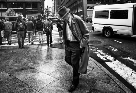 NEW YORK, USA - May 04, 2016: Black and white image of Manhattan street scene. An elderly man in a raincoat and a hat is crossing the streetのeditorial素材