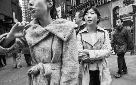NEW YORK, USA - May 03, 2016: Black and white Manhattan street scene. New Yorkers and tourists walking on the streets of Manhattan in NYC. Two women of eastern appearance on Times Squareのeditorial素材