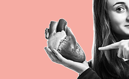 Young woman with heart in hand. Magazine style collage with copy space and trendy coral color background. Abstract creative backgroundの写真素材