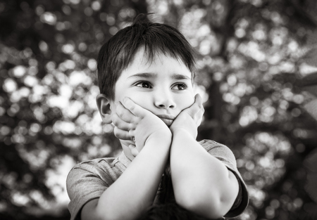 Family and happy lifestyle concept. Portrait of a little boy on the background of a blurred cityscape.の写真素材