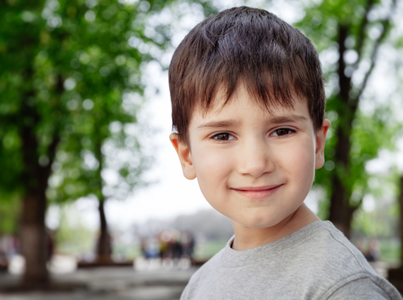 Family and happy lifestyle concept. Portrait of a little boy on the background of a blurred cityscape.の写真素材