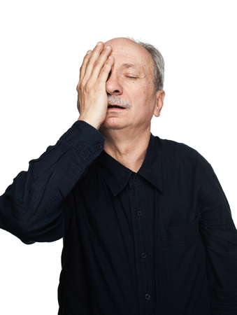 Health and illness concept. Elderly man suffers from headache and holds his head by hand isolated on white with copy spaceの写真素材