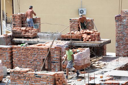 UZHGOROD, UKRAINE - Jul. 11, 2018: A team of professional craftsmen builds a brick house....