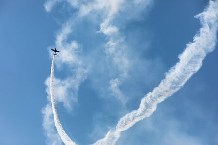 IVANO-FRANKIVSK REG, UKRAINE - Jun. 15, 2019: Silhouette of an airplane with a trace of smoke behind...