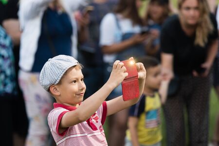 IVANO-FRANKIVSK REG, UKRAINE - Jun. 15, 2019: Boy with a smartphone at the festival Polonynsky Summer, traditional cultural festival at Hutsulshchynaのeditorial素材