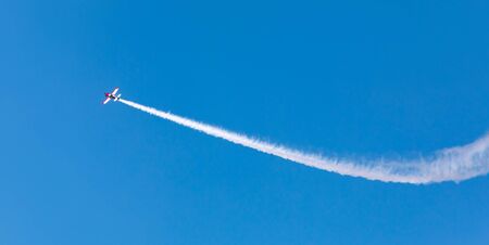 IVANO-FRANKIVSK REG, UKRAINE - Jun. 15, 2019: Silhouette of an airplane with a trace of smoke behind performing acrobatic flight on blue sky at air showのeditorial素材