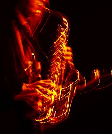 Jazz music concept. Abstract motion blurred image of saxophone player performing on stage. Sax player going crazy.の写真素材