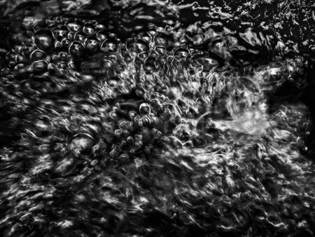 Abstract nature background. Image of the water surface of a forest stream. Bubbles and flow of water