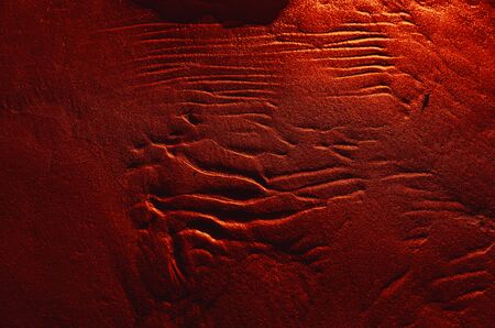Dunes on the sea shore. Ripples in wet sand background texture. Beach sand background