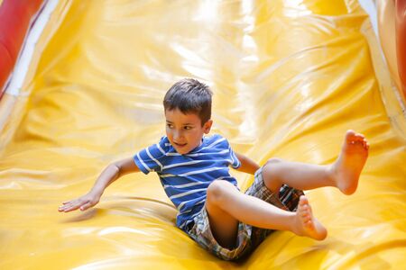 Boy playing on the slide playground enjoying time in the parkの写真素材