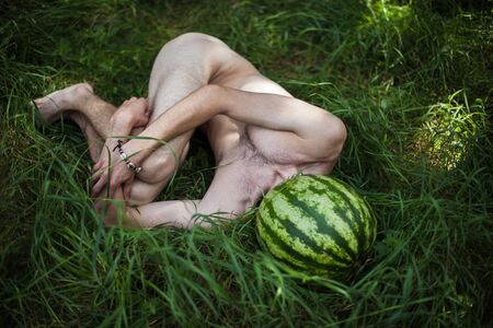 Organic food and healthy lifestyle concept. Humorous ironic photo of a boy with a watermelon instead of head on nature backgroundの写真素材
