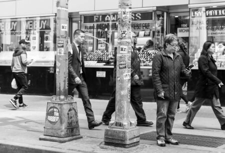 NEW YORK, USA - Apr 27, 2016: Manhattan street scene. Woman with cigarette and mobile phone in the...