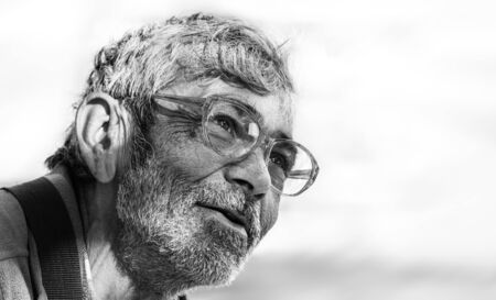 UZHGOROD, UKRAINE - Apr. 19, 2019: Black and white image of homeless beggar man outdoors in city,...