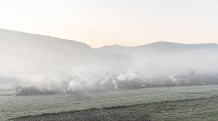 Spring morning in a mountain village. Foggy morning and flowering treesの写真素材