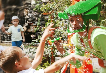 UZHGOROD, UKRAINE - Aug. 20, 2015: Clowns show soap bubbles to children during a children's holiday. Children and adults play soap bubblのeditorial素材