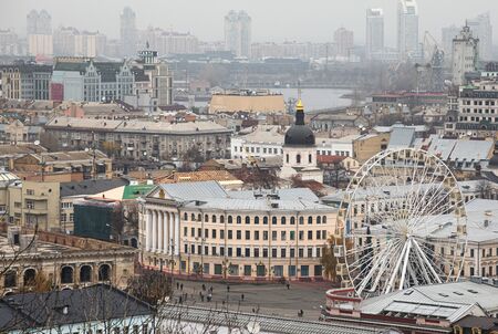 Kyiv, Ukraine - Nov. 16, 2019: Cityscape of Podol district in Kyiv city at foggy day. Kontraktova square and Ferris wheelのeditorial素材