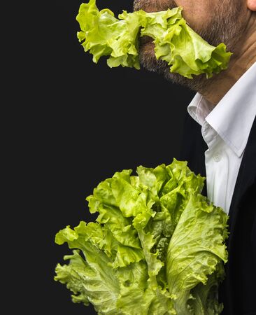 Healthy lifestyle and healthy eating concept. Man holding and eating lettuceの写真素材