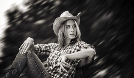 Lifestyle and beauty concept. Sexy cowgirl. Black and white image of young woman in a hatの写真素材