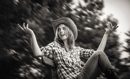 Lifestyle and beauty concept. Sexy cowgirl. Black and white image of young woman in a hatの写真素材