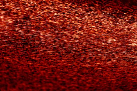 Abstract background. Shiny water splashes. Jets and drops of fountain.  Dramatic red and black image