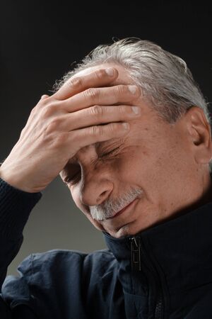 Portrait of an elderly man with a headache. Old man with infection and high temperatureの写真素材