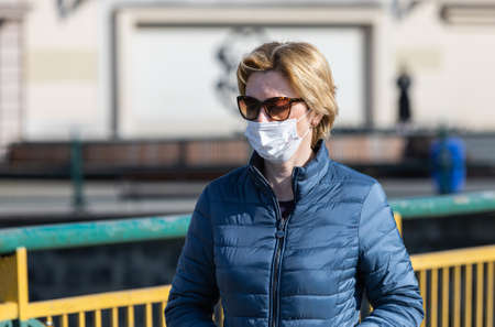 Uzhgorod, Ukraine - Apr. 10, 2020: People in medical masks on the street rush about their business...