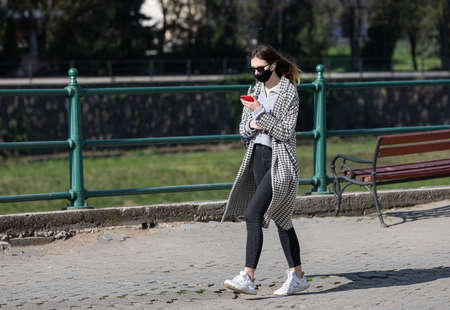 Uzhgorod, Ukraine - Apr. 10, 2020: People in medical masks on the street rush about their business...