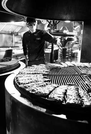 Lviv, Ukraine - May 23, 2020: Cooking fried ribs. Arsenal Ribs And Spirits. Medieval Themed restaurant near the armoury. Very popular place among tourists.のeditorial素材