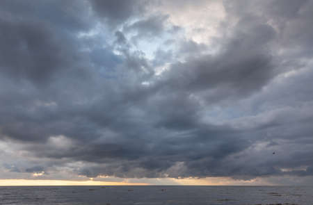 Amazing dramatic landscape. Dramatic dark clouds during sunset at sea. Dark sea water and heavy...