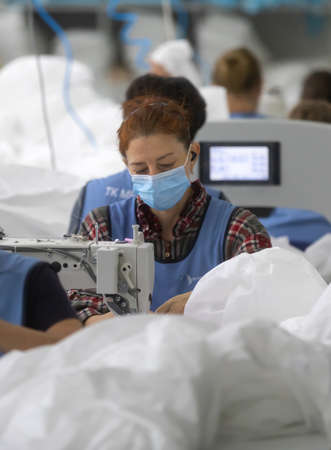 CHERNIGIV, UKRAINE - Oct. 06, 2020: Sewing of protective suits for medics and doctors during covid-19 pandemic in sewing factory TK-Style in Chernigiv, Ukraineのeditorial素材