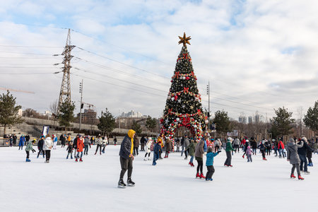 KYIV, UKRAINE - Dec. 27, 2020: Ice-skating people. People have fun in ice arena at the city ice rink. New Years holidays in city Kyiv. Kyiv Christmas and New Year decorations.のeditorial素材