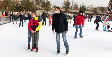 KYIV, UKRAINE - Dec. 27, 2020: Ice-skating people. People have fun in ice arena at the city ice...