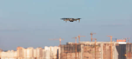 Drone flies against the backdrop of a big city. Focus on drone with blurred background