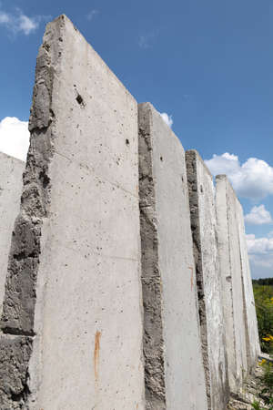 Old concrete slabs standing on a summer sunny day in the field. Old unfinished building