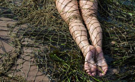 Young nude woman on the beach with a fishing netの写真素材
