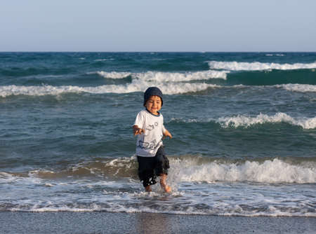 Healthy lifestyle. A little boy walks and plays on the seashore.の写真素材