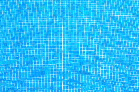 Blue tiles on the bottom of the pool. Ripples distorting the blue tile lining of a pool. Top view...