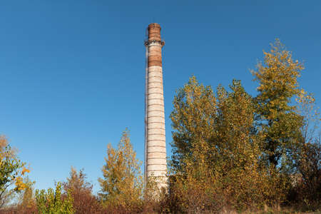 Large brick chimney. Tall factory chimney made of brick against blue skyの写真素材