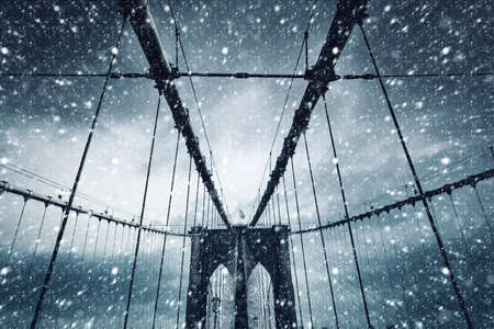 Brooklyn Bridge in New York City. Brooklyn Bridge in winter during snowfallの写真素材