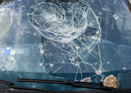 Car glass shattered by a stone. Broken car windshield. Criminal incidents. Vandals, hooligans mutilated the car, smashed the windshieldの写真素材