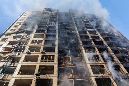 KYIV, UKRAINE - Mar. 15, 2022: War in Ukraine. General view of a badly damaged residential building in the smoke from the fire that was hit by a Russian shell.のeditorial素材