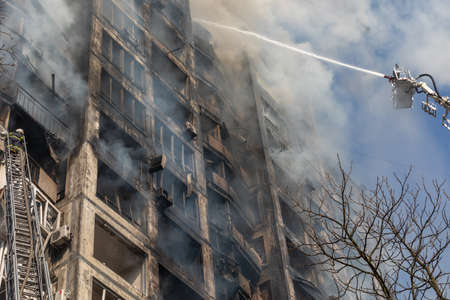 KYIV, UKRAINE - Mar. 15, 2022: War in Ukraine. Firefighters fighting a fire in a residential building that was hit by a Russian shell.のeditorial素材